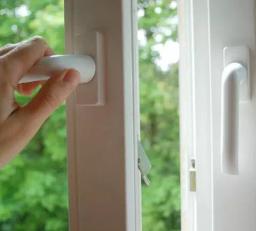 Hand öffnet Fenster zum Lüften
