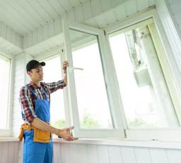 Handwerker prüft Dichtungen an Fenstern