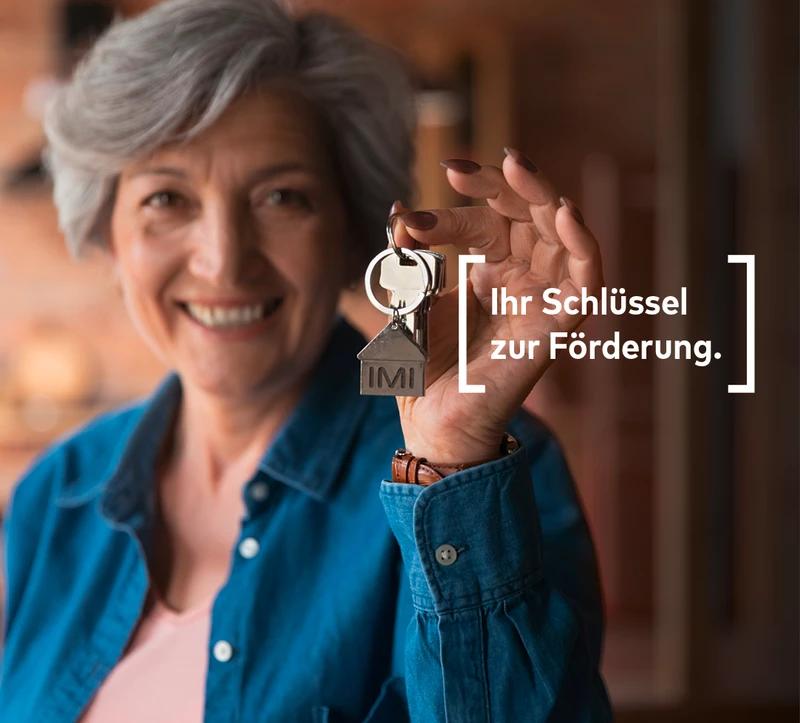 Frau mit Wohnungsschlüssel und Slogan Ihr Schlüssel zur Förderung